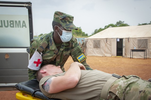 A medic from the Rwanda Defense Force's Medical Corps moves a patient -- in this case a volunteer from the Nebraska Army National Guard -- toward a United Nations Level 2 Hospital during a medical/engineering exercise conducted at Gako, Rwanda, in March. The exercise enabled members of the Rwanda Defense Force and the Nebraska National Guard to work together through the National Guard's State Partnership Program. (Nebraska Air National Guard photo by Lt. Col. Kevin Hynes)