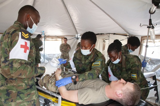 Rwanda Defense Force medics treat a simulated patient - a Nebraska Army National Guard volunteer - at a United Nations level two hospital during a medical/engineering exercise at Gako, Rwanda, in March 2022. Rwanda and Nebraska are partners under the Department of Defense National Guard Bureau State Partnership Program. (Nebraska Air National Guard photo by Lt. Col. Kevin Hynes)