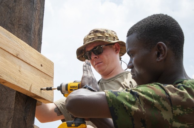 A member of the Nebraska Army National Guard's Wahoo-based 623rd Engineer Company works with a Soldier from the Rwanda Defense Force's Engineer Brigade to construct a guard tower on March 16.  (Nebraska Air National Guard photo by Lt. Col. Kevin Hynes)