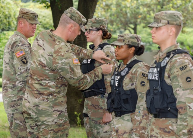 Capt. James Martin, left, commander of the 88th and 901st Military Police Detachments, replaces the U.S. Army Japan patch with a U.S. Army Materiel Command patch on the uniforms of his Soldiers during a ceremony at Camp Zama, Japan, July 12, 2022. The new patch signified the realignment of both units from USARJ to U.S. Army Garrison Japan. 