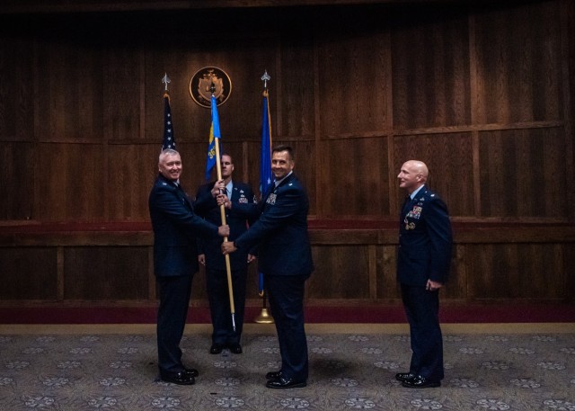 Air Force Lt. Col. Ben Carlson (second from right) takes the 368th Training Squadron guidon from Col. Daniel Lemon (left), 782nd Training Group commander at Sheppard Air Force Base, Texas, during a change-of-command ceremony Monday in the U.S. Army Engineer Regimental Room at the John B. Mahaffey Museum Complex. Carlson replaced Lt. Col. Allen Branco (right), who moves on to the National Capital Region, where he will assume the role of 11th Mission Support Group deputy commander at Joint Base Anacostia-Bolling. 
