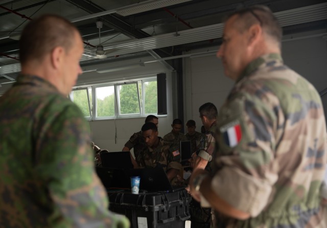 French and Finnish soldiers discuss operations during  Artillery Systems Cooperation Activities training at Grafenwoehr Training Area, Germany, July 10, 2022. Dynamic Front 2022, led by 56th Artillery Command and U.S. Army Europe and Africa directed, is the premiere U.S. led NATO Allied and Partner integrated fires exercise in the European Theater focusing on fire interoperability and increasing readiness, lethality and interoperability across the human, procedural and technical domains. (U.S. Army photo by Spc. Dominique' Crittenden, 5th Mobile Public Affairs Detachment)