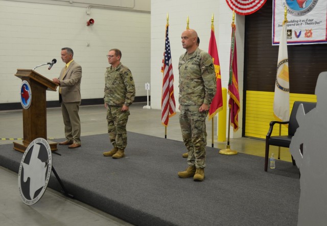 Brian Butler, left, deputy to the commanding general, U.S. Army Tank-automotive and Armaments Command prepares to speak to the audience following the depot colors being passed. Also pictured are the newest commander of River Army Depot Col....