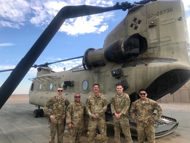 Five Washington National Guard crew members pose in front of their CH-47 Chinook helicopter, damaged in Afghanistan Nov. 20, 2020. All five were awarded the U.S. Army Aviation Broken Wing Award in a ceremony at the Army Aviation Support Facility...