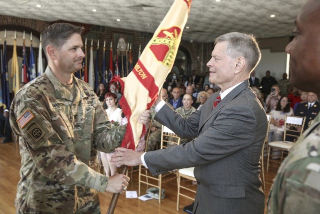 Col. Craig Martin (left), outgoing commander of U.S. Army Garrison Fort Hamilton, hands the garrison