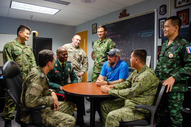 International military students talk with Micah Pereza (blue shirt) and Spc. Christopher Barry (fourth from left) from the International Military Student Office Wednesday at the IMSO, which currently hosts more than 70 students from 60-plus countries. 