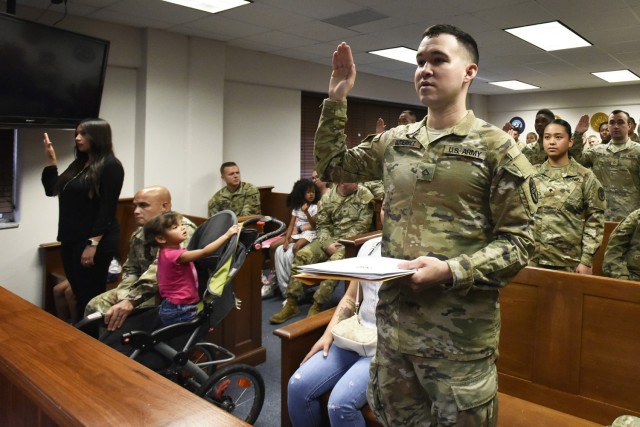 Pfc. Diego Gutierrez and 12 other Fort Leonard Wood service members and dependents recite the Oath of Allegiance during a naturalization ceremony held Wednesday at the Office of the Staff Judge Advocate courtroom – in conjunction with the U.S. Citizenship and Immigration Services and the U.S. Courts, Western District of Missouri. The 13 individuals, from 11 countries, include Catalina Blakely, Adams Sahly Lebaine Diabate, Martha Diaz, Diego Gutierrez, Dwayne Halstead, Jessica Hernandez Vazquez, Presnel Joseph, Josue Lagos Diaz, Grace Parkinson, Mary Quibal, Ryan Taifane, Hao Wang, and Kadir Yigitbas. 