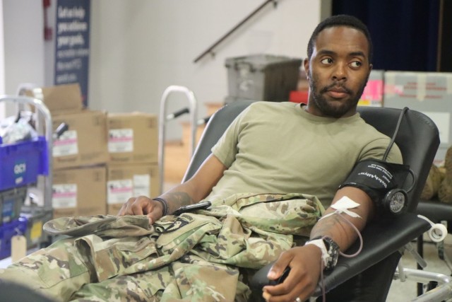 Private First Class Demario Grant, 1st Battalion, 26th Infantry Regiment, 2nd Brigade Combat Team, 101st Airborne Division (Air Assault), squeezes a stress ball while donating blood July 12 at USO Fort Campbell during an American Red Cross collection drive.