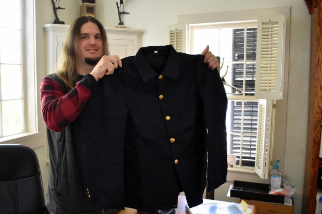 Jordan Leininger, an artifacts specialist with the City of Monterey’s Museum and Cultural Arts Division, holds up a reproduction uniform coat for a planned exhibit on Buffalo Soldiers stationed at the Presidio of Monterey in 1902-1904.