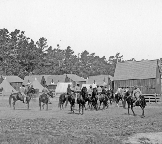 Buffalo Soldiers stationed at the Presidio of Monterey in the early 1900s train with horses.