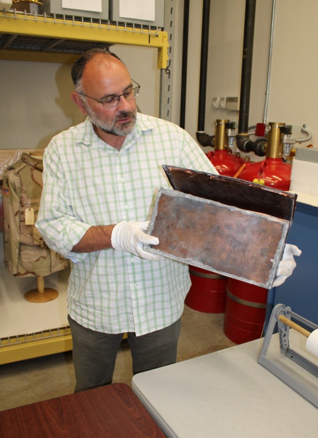 Courtney Burns, director of the New York State Military Museum, examines a copper box time capsule discovered inside the cornerstone of the original section of the New York National Guard’s historic Harlem Armory during renovation work. The box contained documents pertaining to the 369th “Harlem Hellfighters” of World War I fame and documents of importance to the Black community in 1923 New York City.