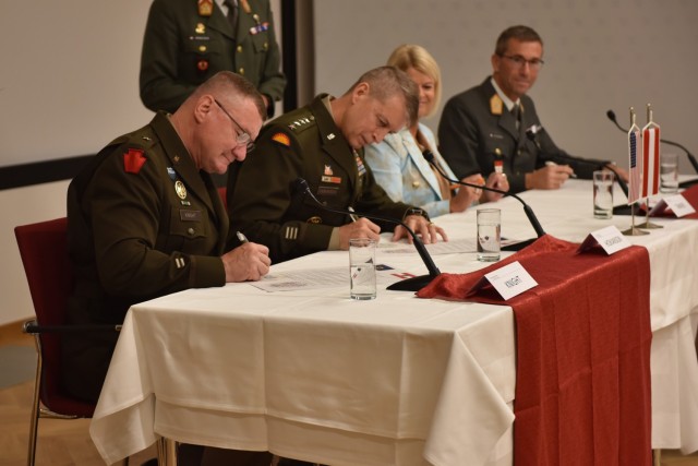 U.S. Army Brig. Gen. Gregory Knight, left, Vermont adjutant general, and U.S. Army Gen, Daniel Hokanson, center left, chief of the National Guard Bureau, sign letters of intent with the Republic of Austria in Vienna, Austria, July 19, 2022.  This is the third state partnership for the Vermont National Guard, which has partnered with North Macedonia since 1993 and Senegal since 2008. (U.S. Army National Guard Photo by 1st Lt. Nathan Rivard)