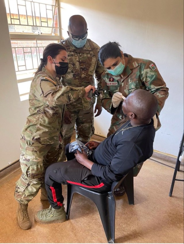New York Army National Guard Staff Sgt. Christine Iraci, left, and Army Reserve Maj. Dwayne Bodielook on as Anissa Talib-Ally with the South African Military Health Service checks a patient outside Richards Bay, South Africa, during a medical readiness visit July 25, 2022, as part of Exercise Shared Accord. The every-other-year exercise teams American military personnel with those from an African nation. (Courtesy photo)