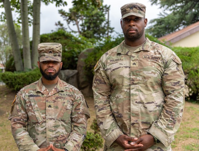 Sgt. Cortez Moore and Sgt. Brian Yeldell of Headquarters and Headquarters Company, U.S. Army Garrison Daegu pose inside the walls of Camp Henry, Republic of Korea, July 28, 2022. Both Soldiers are direct descendants of Korean War veterans.