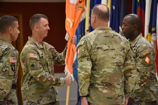 Col. Paul D. Howard, U.S. Army Signal School commandant and 42nd Chief of Signal, passes the guidon to Command Sgt. Maj. Darien Lawshea, U.S. Army Signal School regimental command sergeant major, during a change of responsibility ceremony held July 15.