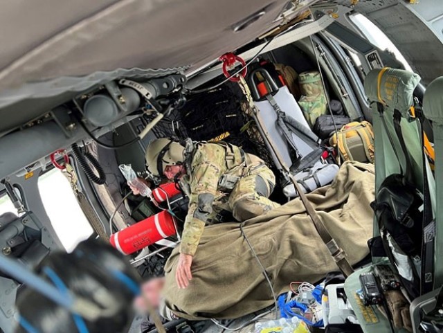 A Tennessee Army National Guard Soldier comforts a patient rescued from the flooding in eastern Kentucky while being flown to a hospital July 28, 2022. The Tennessee National Guard sent five Black Hawk helicopters and crews to assist in search and rescue efforts. (Tennessee National Guard)
