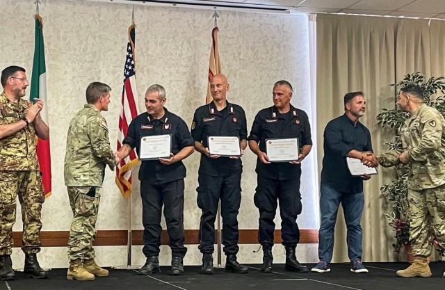 Col. Matthew Gomlak, commander of U.S. Army Garrison Italy, and 1st Sgt. Jonathan Risher, present length of service awards to Italian carabinieri.