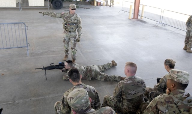 With PV2 Kyle Daniel of the 810th Military Police Company in the prone position, Sgt. 1st Class Michael Dendy, an observer coach/trainer with First Army’s 177th Armored Brigade, gives instruction on operating the M249 during Pershing Strike 22 at Camp Shelby, Miss.
