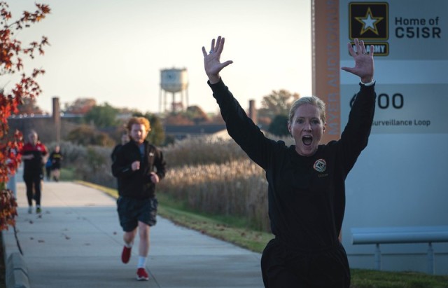 U.S. Army Communications-Electronics Command Sgt. Maj. Kristie Brady excitedly crosses the finish line during the first-ever CECOM “fun run” at the C5ISR campus Nov. 10, 2021. 