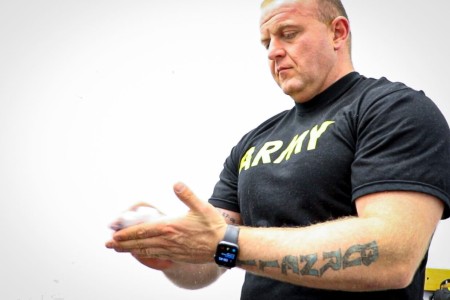 U.S. Army Sgt. 1st Class Timothy Burnell, battalion noncommissioned officer, Troop Command, Landstuhl Regional Medical Center, prepares his grip with magnesium carbonate, or lifting chalk, during a training evolution, July 1. Burnell, a native of Roseburg, Oregon, recently placed first in a powerlifting competition at Ramstein Air Base, Germany, lifting a combined weight of 1,529 pounds in three compound exercises (bench press, squat, deadlift).