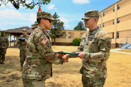 Capt. Phillip Herold, Headquarters and Headquarters Battery, 75th Field Artillery Brigade commander, left, presents the Army Commendation Medal to Pfc. Jason Hernandez July 28, 2022, for his actions on the night of July 25 when he saved a teammates life.
