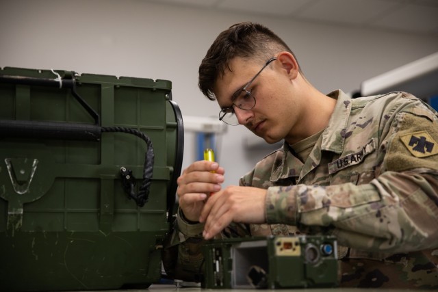 Spc. Robert Morris, a radio equipment repairer with Company B, 700th Brigade Support Battalion, 45th Infantry Brigade Combat Team, Oklahoma National Guard, works on a SINCGARS radio at the Sustainment Training Center on Camp Dodge near Johnston City, Iowa, July 18, 2022. Repairers assigned to the 700th BSB conducted technical repair training in a realistic, multi-echelon environment as part of their annual training. (Oklahoma National Guard photo by Spc. Danielle Rayon)