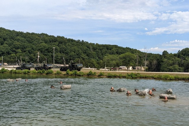 Combat engineer and bridge crewman trainees assigned to Company B, 35th Engineer Battalion, traverse the Training Area 250 lake with poncho rafts July 12. The lesson on building and utilizing poncho rafts was an extra training opportunity only afforded to units of trainees that excel at their program of instruction and have time to spare. 