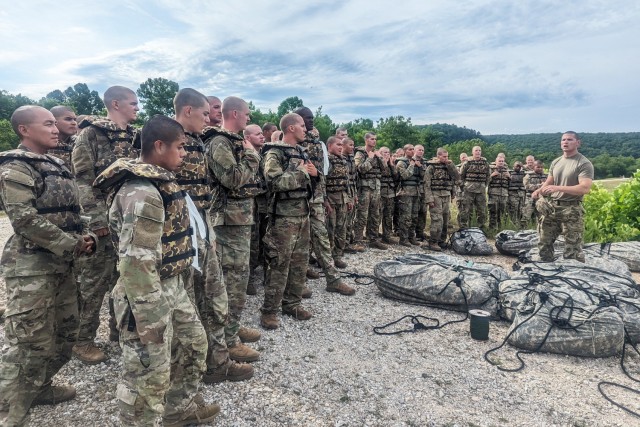 Sgt. 1st Class Nathan Hale, a drill sergeant with Company B, 35th Engineer Battalion, instructs trainees on July 12 before they cross the lake with poncho rafts at Training Area 250.