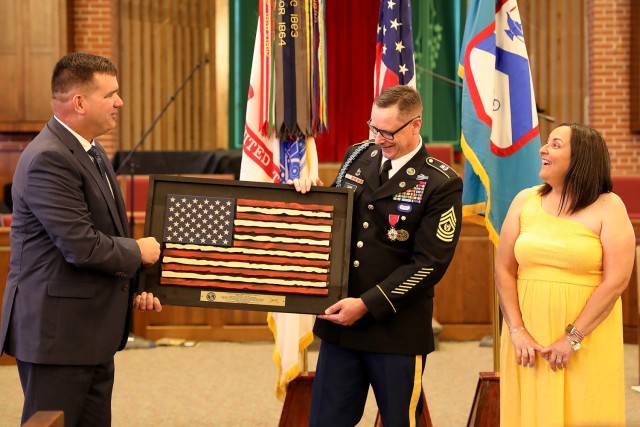 Combined Arms Center-Training Deputy Ed Bohnemann presents CAC-T Senior Enlisted Advisor Sergeant Maj. Thomas Conn and his wife Kathie with a gift during Conn’s retirement ceremony at the Pioneer Chapel, Fort Leavenworth, Kan. July 29, 2022. Because Conn served as a Command Sgt. Maj. in previous assignments, he retired with that rank. Photo by Tisha Swart-Entwistle, Combined Arms Center-Public Affairs.