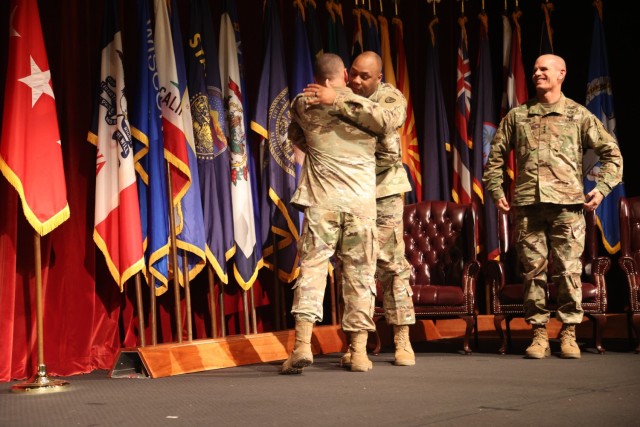 U.S. Army Installation and Management Command Sergeant Major Jason Copeland embraces former IMCOM Command Sergeant Major Joe Ulloth as IMCOM Command General Lt. Gen. Omar Jones smiles during a Change of Responsibility Ceremony Aug. 5, 2022, at the Fort Sam Houston Theater at JBSA-Fort Sam Houston, Texas. 