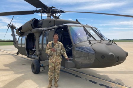 Army 2nd Lt. Gabrielle Cole poses with a UH-60 Black Hawk, which she pilots for the Illinois National Guard.