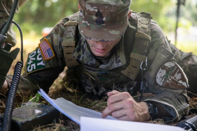 Army Sgt. Spencer Fayles programs a radio during the Army National Guard Best Warrior Competition in Milan, Tenn., July 26, 2022.