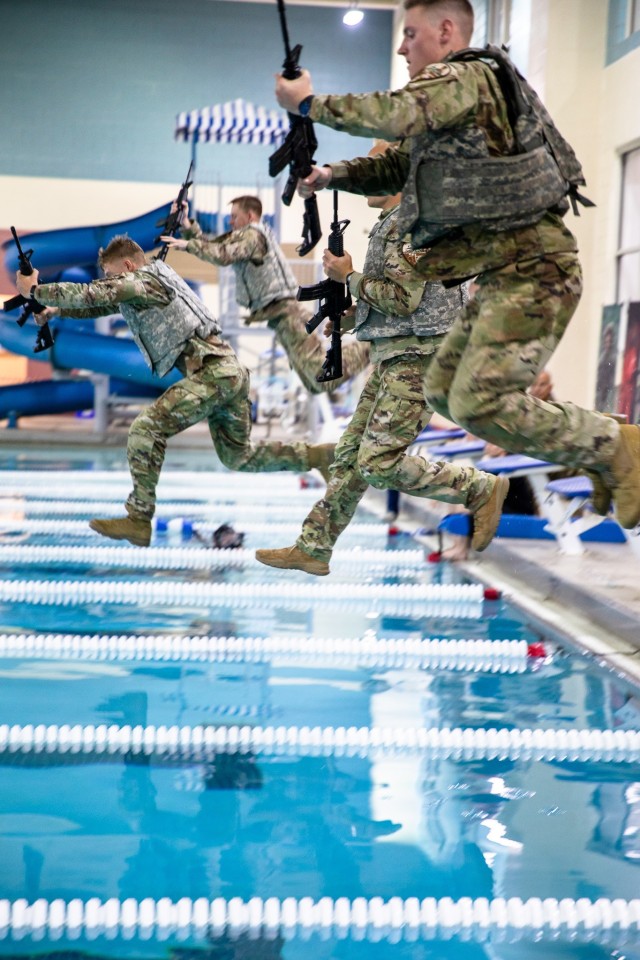 Soldiers competing in the Army National Guard Best Warrior Competition jump into a pool during a survival swim event at Middle Tennessee State University in Murfreesboro, Tenn., July 25, 2022.