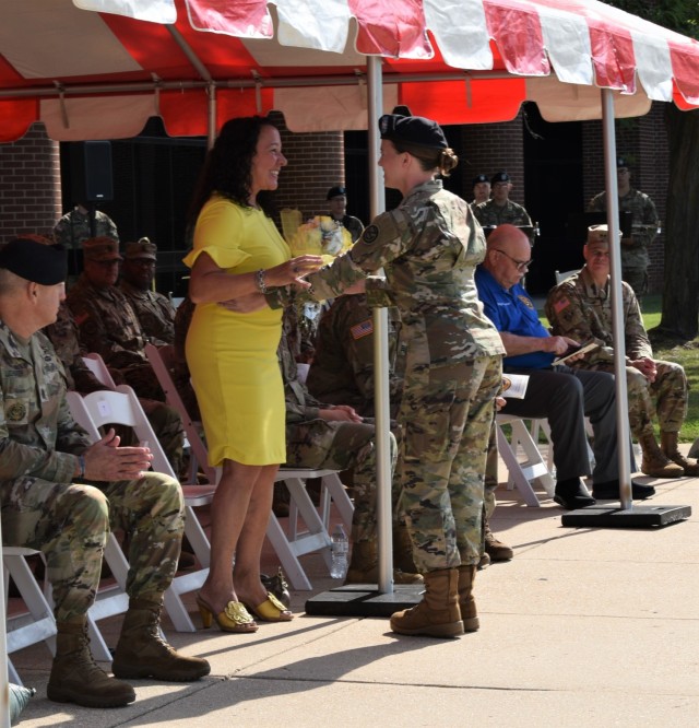 Mrs. Warne, wife of the incoming commanding general of the 102nd Training Division, receives yellow roses during the division&#39;s change of command ceremony at the Maneuver Support Center of Excellence Plaza at Fort Leonard Wood, Missouri, Aug. 13, 2022. The roses are a symbol of friendship welcoming her to the command.