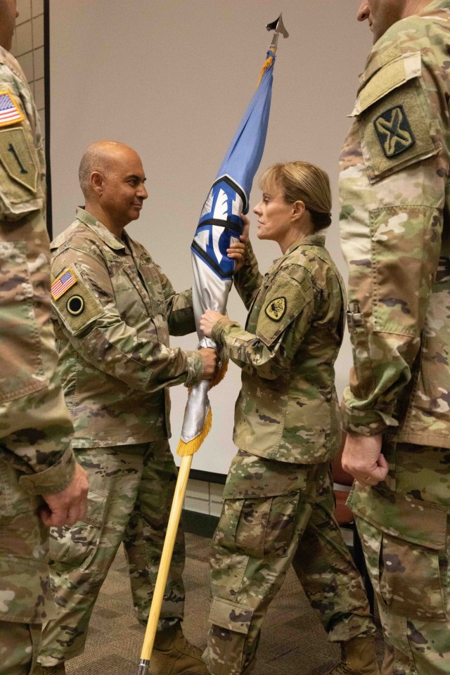 Col. Shahram Takmili passes the organizational colors to Brig. Gen. Charlene Dalto representing the relinquishing of command during the 300th Military Intelligence Brigade change-of-command ceremony, Aug. 6, 2022, at Camp Williams, Utah. During the ceremony, Col. Shahram Takmili relinquished command to Col. Cody Strong. (U.S. Army photo by Staff Sgt. Derrik Cowley)