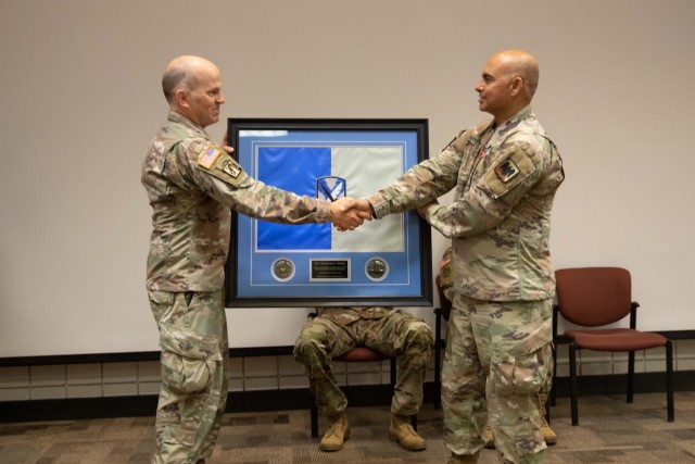 Lt. Col. Jeremy Stevenson, presents a gift to Col. Shahram Takmili, during the 300th Military Intelligence Brigade change-of-command ceremony, Aug. 6, 2022, at Camp Williams, Utah.  Stevenseon, the deputy commander of the 300th MI, provided the gift on behalf of the Soldiers of the 300th MI to show appreciation for Takmili’s service as the brigade commander from 2019 to 2022. During the ceremony, Col. Shahram Takmili relinquished command to Col. Cody Strong. (U.S. Army photo by Staff Sgt. Derrik Cowley)