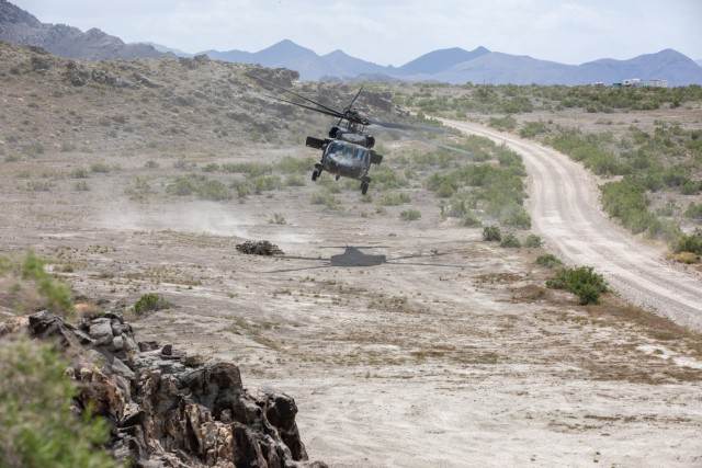 A helicopter flies over desert terrain at Dugway Proving Ground, Utah.