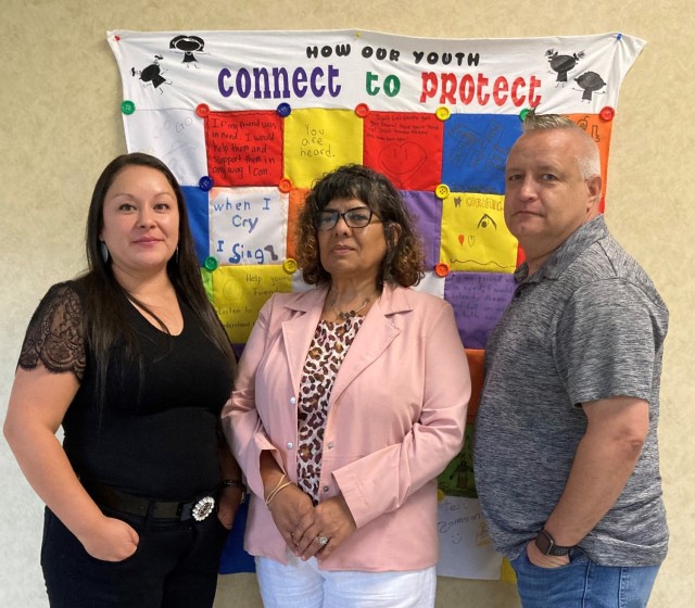 The WSMR Garrison Army Substance Abuse Program team, which includes Sandra Class, Amanda Carreras and Adam Judd stand in front of the quilt created as part of one of the activities during Suicide Prevention Month.
