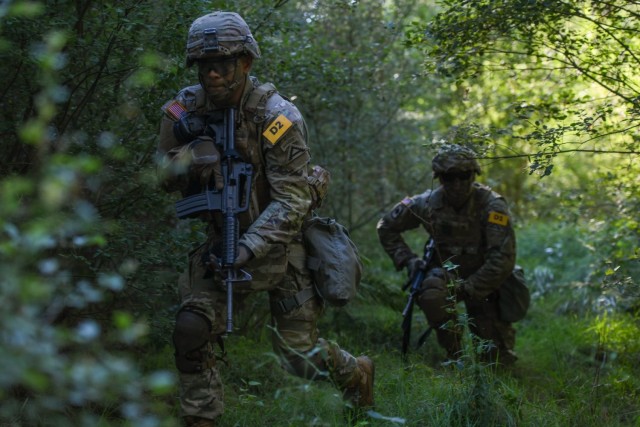 U.S. Army Sgt. Alexis Ortiz-Rivera, left, and Staff Sgt. William Powell, both assigned to 7th Army Training Command team, tactically move through the terrain during the U.S. Army Europe and Africa Best Squad Competition at Grafenwoehr Training Area, Germany, Aug. 9, 2022. 