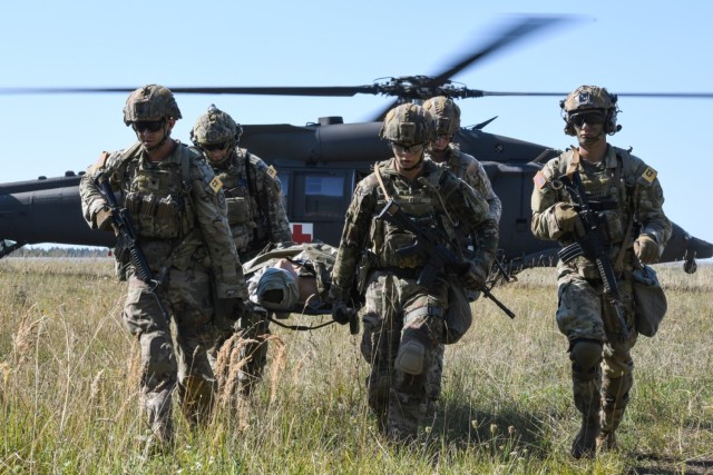 U.S. Soldiers assigned to V Corps team carry a mannequin to a secure area during the U.S. Army Europe and Africa Best Squad Competition at Grafenwoehr Training Area, Germany, Aug. 9, 2022.