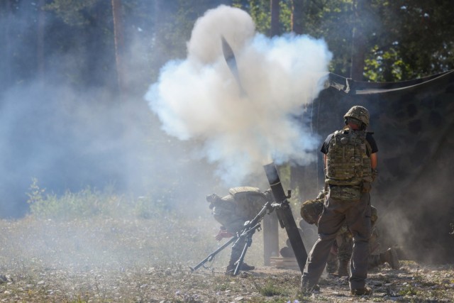 Kevin Payne, Visual Information Specialist with Training Support Activity Europe, films a mortar crew firing rounds during the U.S. Army Europe and Africa Best Squad Competition at Grafenwoehr Training Area, Germany, Aug. 10, 2022.