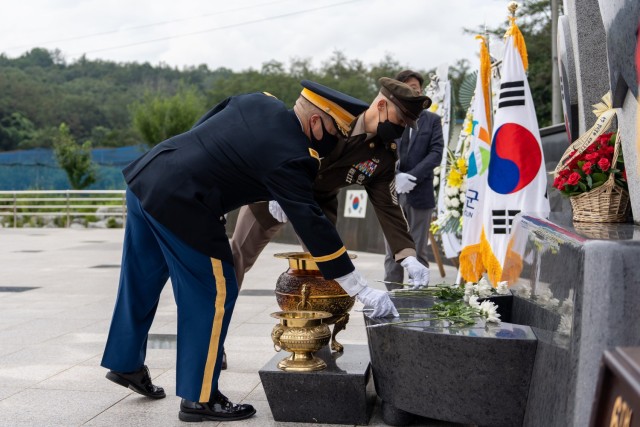 U.S. Army Garrison Daegu Commander Col. Brian P. Schoellhorn and U.S. Army Garrison Daegu Senior Enlisted Leader Command Sgt. Maj. Jonathon J. Blue place flowers on a monument during a wreath laying ceremony in Waegwan, Republic of Korea, August 17, 2022. The ceremony was held in memory of the 41 U.S. Army Soldiers who were murdered by North Korean troops at Hill 303 on August 17, 1950.
