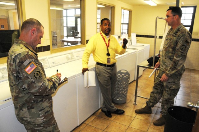 Fort Polk garrison Command Sgt. Maj. Stephen Nielson, (left) takes notes as he and other inspection team members check the condition of a barrack’s laundry room July 26.