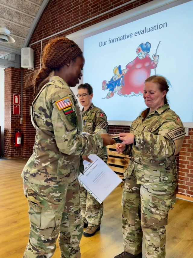 Connecticut National Guard Capt. Shaneka Ashman, operations officer for the 143rd Regional Support Group, receives a certificate of completion for the Military Reserve Exchange Program at Camp Nymindegab in Denmark around July 8, 2022. Ashman was one of approximately 50 American Soldiers who participated in the course alongside approximately 90 NATO students. (U.S. Army photo)