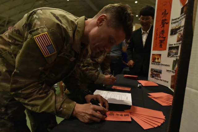 2nd Lt. Timothy Skinner, a Basic Officer Leader Course student here, attempts to write a phrase in Taiwanese at the Know Your World event Friday at Nutter Field House. 