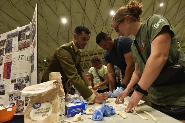2nd Lt. Thorin Jean, a Basic Officer Leader Course student here (right), and 1st Sgt. Mario Jeri, Company C, 31st Engineer Battalion, learn the secrets of making fresh pasta from Italian Capt. Innocenzo Crispo at the Know Your World event Friday at Nutter Field House. 