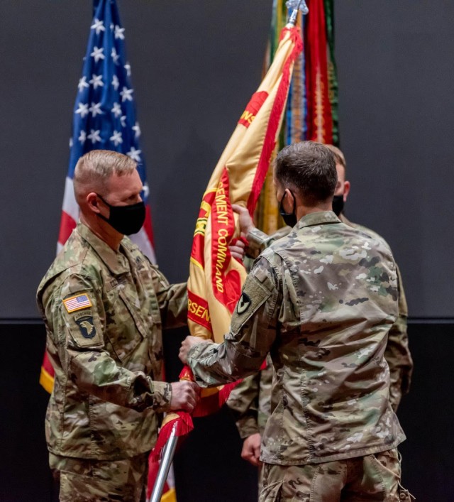 Garrison Commander Col. Brian Cozine accepts the Garrison colors from Col. Scott Halter signifying his assumption of command during the change of command ceremony Thursday.