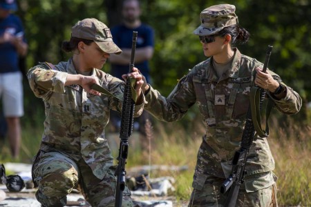 Army Sgt. Christine Won, right, helps Capt. Danielle Rant adjust a rifle sling during a reserve officers military competition at Camp Ethan Allen, Vt., July 19, 2022. The three-day team event consisted of NATO and Partnership for Peace nations in Europe.