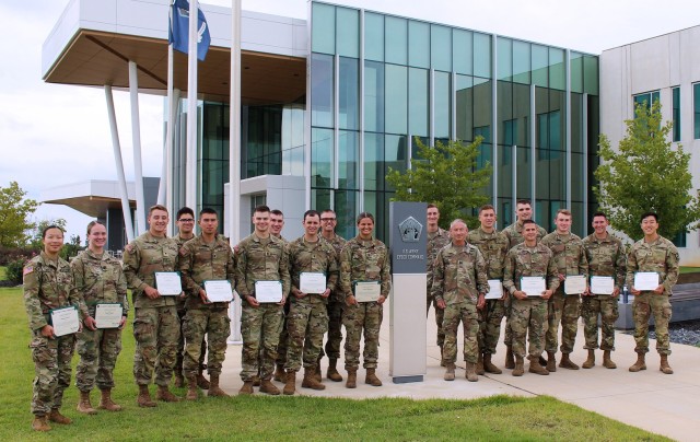 Reserve Officer Training Corps (ROTC) cadets representing 12 universities across the U.S. pose for a photo with Maj. Gen. Neil S. Hersey, Army Cyber Command (ARCYBER) Deputy Commanding General (second to right of sign) at the conclusion of their four-week ROTC internship with ARCYBER, at Fort Gordon, Ga., Aug. 19, 2022. 