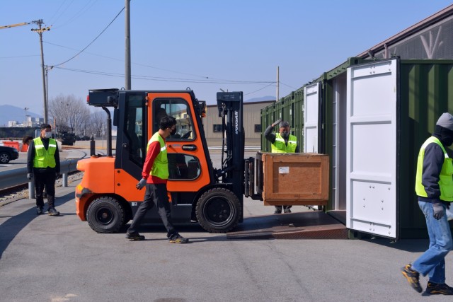 Supply Division personnel from Army Field Support Battalion-Northeast Asia, load a crate of parts into a 20-foot International Organization for Standardization container for storage March 3 at Camp Carroll, South Korea. 